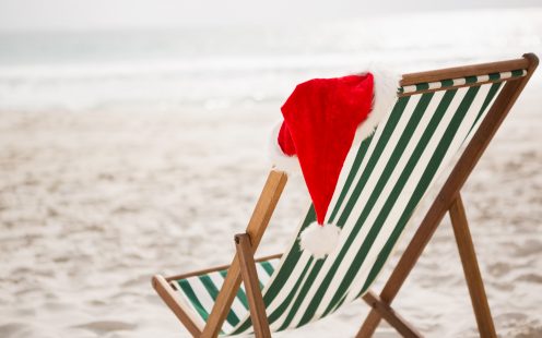 Santa hat kept on empty beach chair at tropical sand beach